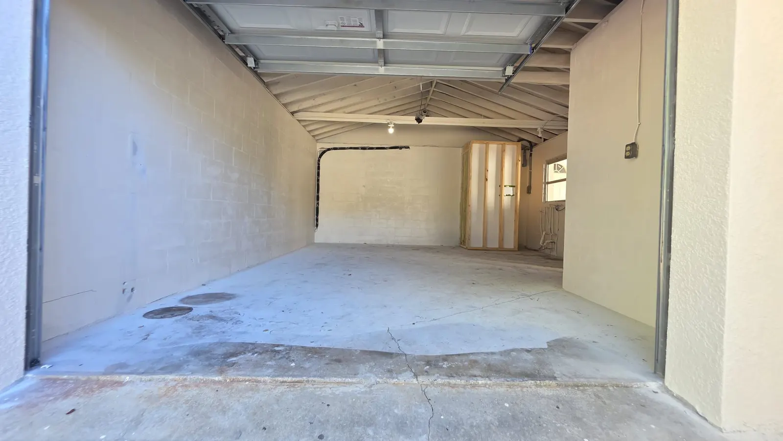 Stained and cracked concrete garage floor before coating