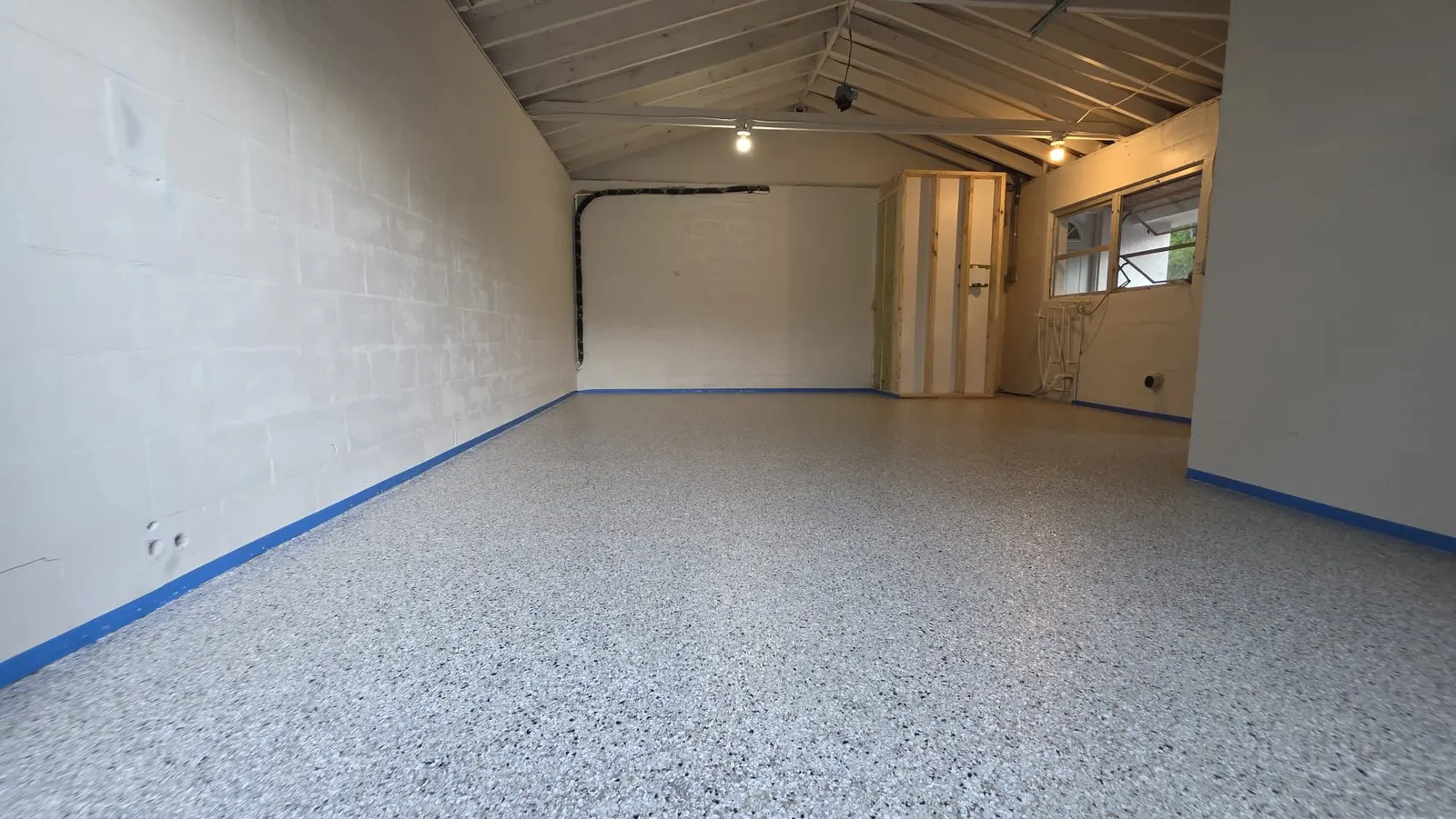 Close view of a gray, white and black flake epoxy garage floor with a glossy top coat